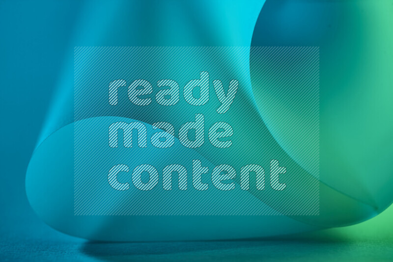 An abstract art piece displaying smooth curves in green and blue gradients created by colored light