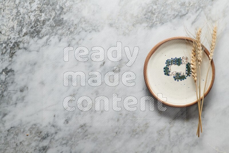 سنابل من القمح علي طبق فخاري مزخرف علي خلفية من الرخام الرمادي