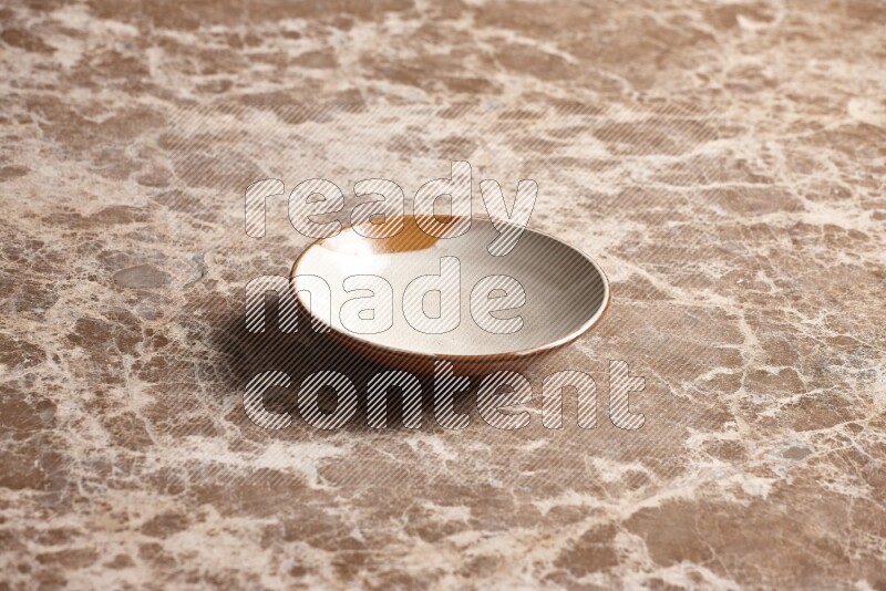 A multicolored pottery plate on beige marble background