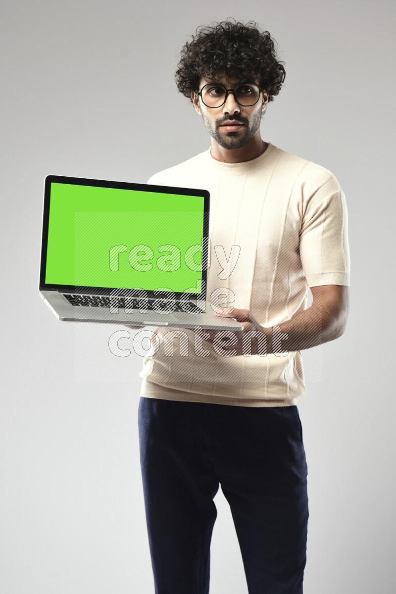 A man wearing casual standing and showing a laptop screen on white background