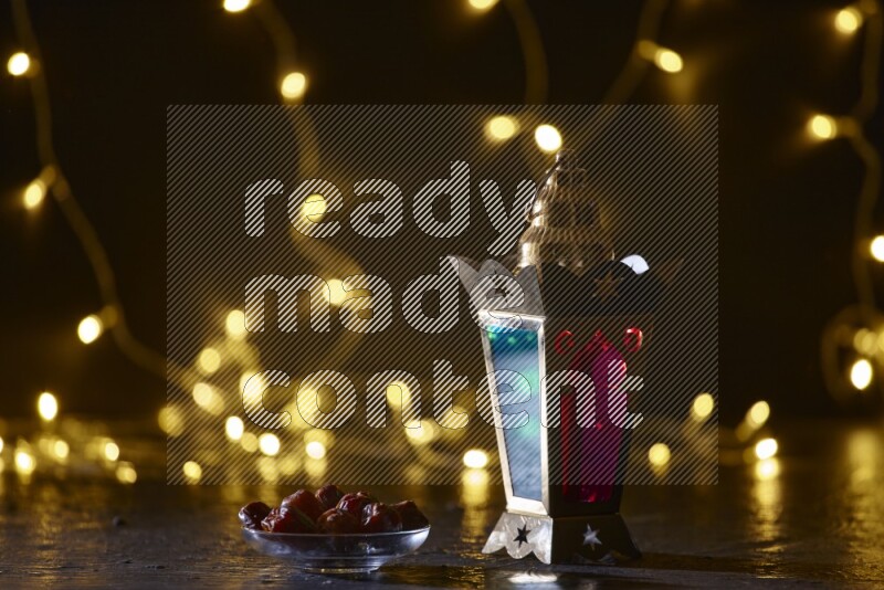 A traditional ramadan lantern surrounded by glowing fairy lights in a dark setup