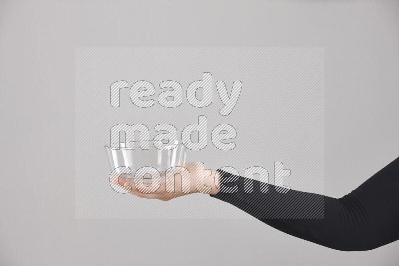 امرأة ترتدي عباءة سوداء تحمل أدوات زجاجية مختلفة في أوضاع متعددة