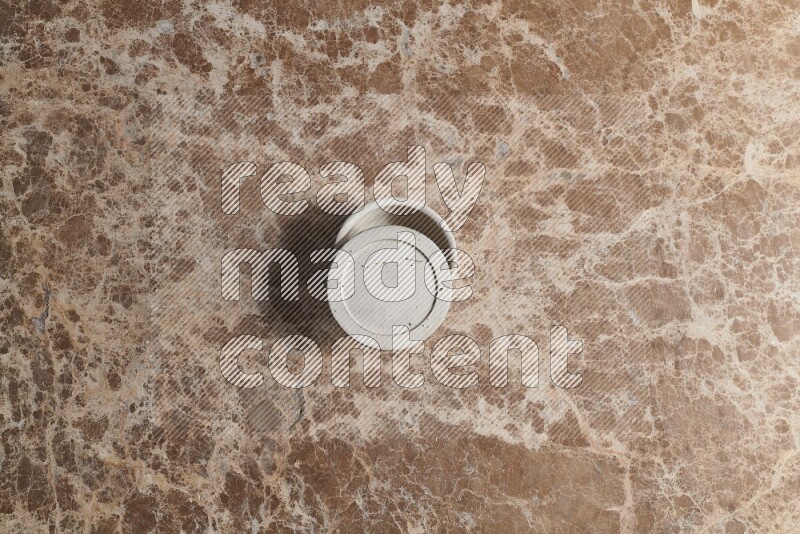A pottery cup on beige marble background