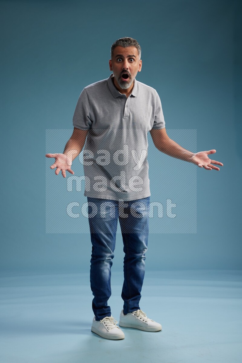 Man Standing Interacting with the camera on blue background