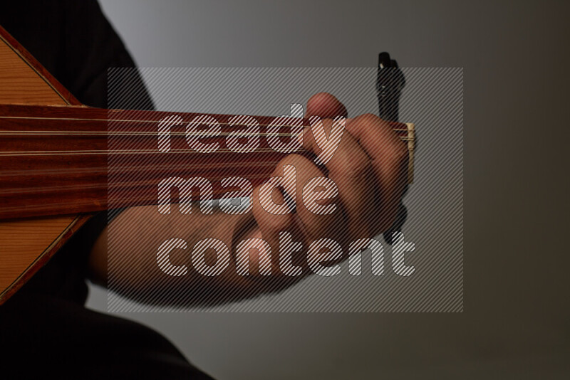 يد رجل تعزف على عود خشبي بني